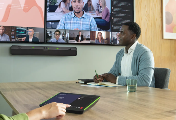 Collaboration space with man looking at screen. This shows a hand pressing the module for the Intellimix Bar Pro.